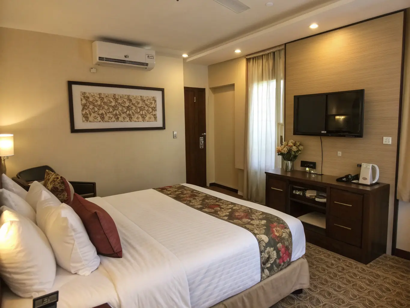A bright, well-furnished room with a large bed, modern decor, and large windows letting in natural light, representing the comfortable rooms at Mernat Pansiyon.